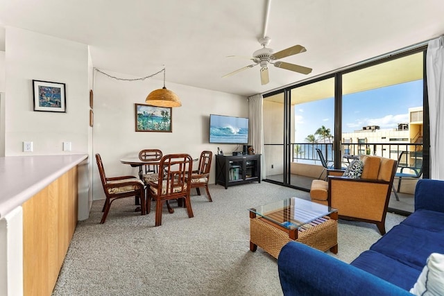 carpeted living room with expansive windows and ceiling fan