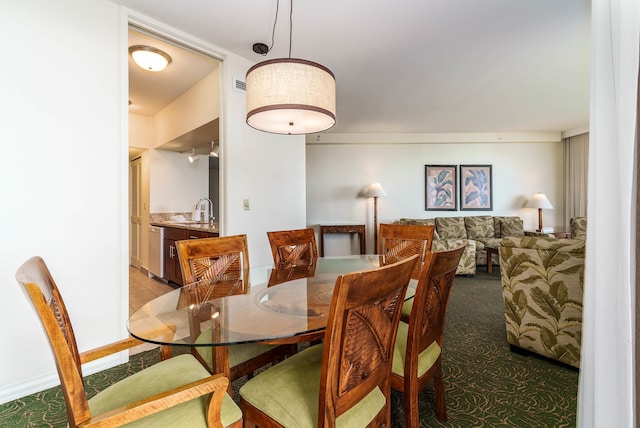 dining space featuring sink and light colored carpet