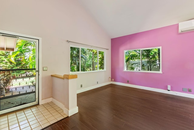 interior space with high vaulted ceiling, baseboards, wood finished floors, and a wall mounted AC