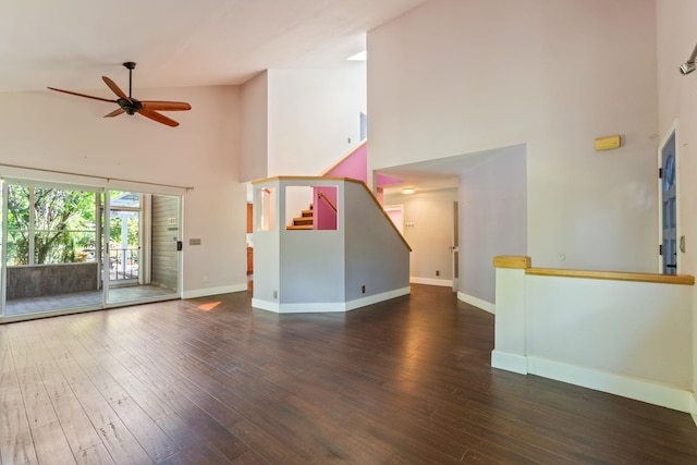 unfurnished living room featuring stairway, baseboards, and wood finished floors