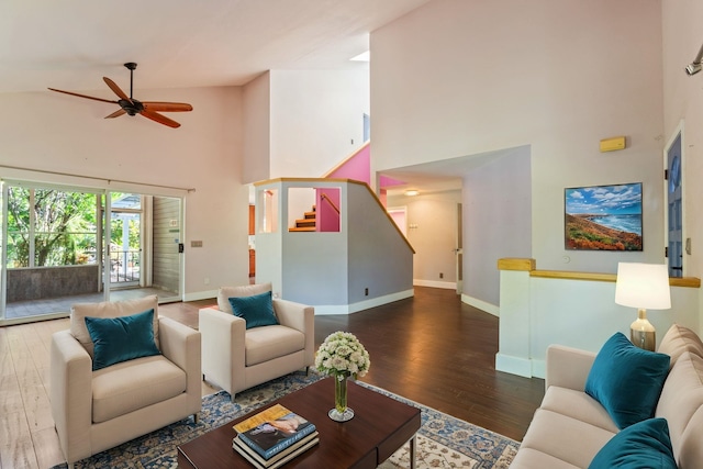 living room with stairs, ceiling fan, baseboards, and wood finished floors