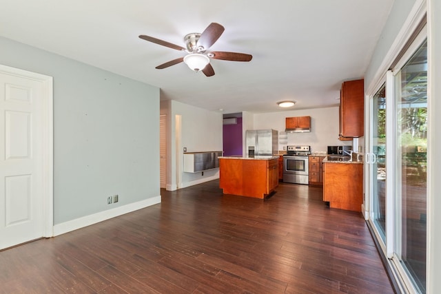 kitchen featuring dark wood-style floors, a kitchen island, appliances with stainless steel finishes, brown cabinets, and open floor plan