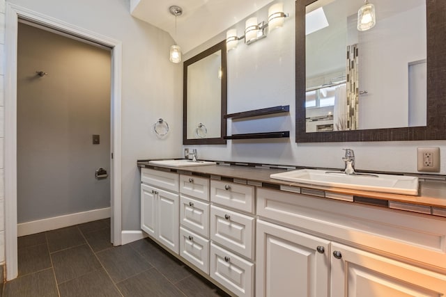 full bathroom with a sink, baseboards, and double vanity