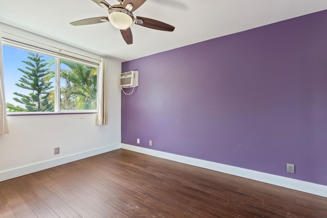 spare room with ceiling fan, baseboards, wood finished floors, and an AC wall unit