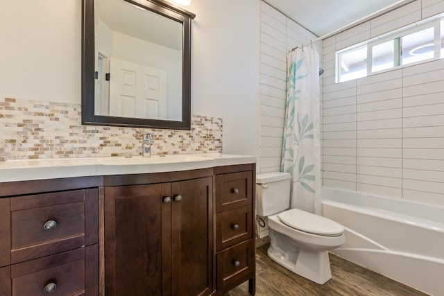 bathroom with tasteful backsplash, shower / bath combination with curtain, toilet, vanity, and wood finished floors