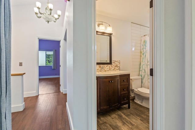 full bathroom featuring toilet, baseboards, wood finished floors, and vanity