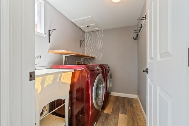 laundry area with laundry area, washing machine and dryer, baseboards, and wood finished floors