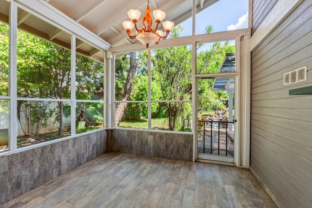 unfurnished sunroom with an inviting chandelier, vaulted ceiling, and a wealth of natural light