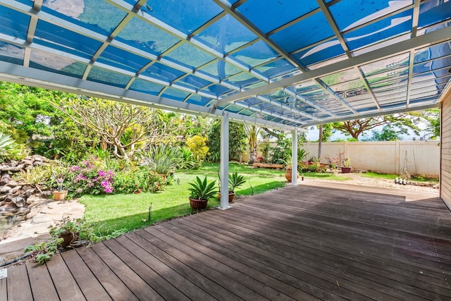 wooden terrace featuring fence and a lawn