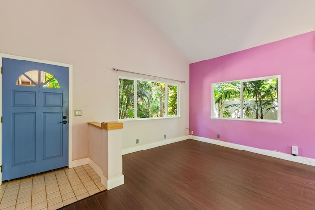 entryway with high vaulted ceiling, baseboards, and wood finished floors