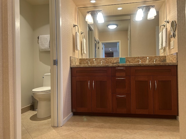 bathroom with toilet, tile patterned flooring, and vanity