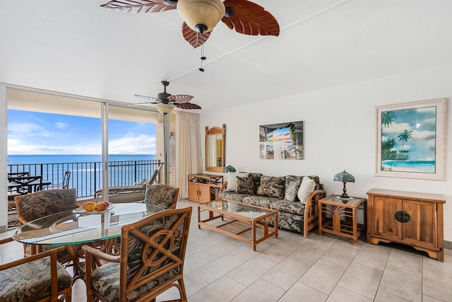 living room with floor to ceiling windows, ceiling fan, a water view, and light tile patterned flooring