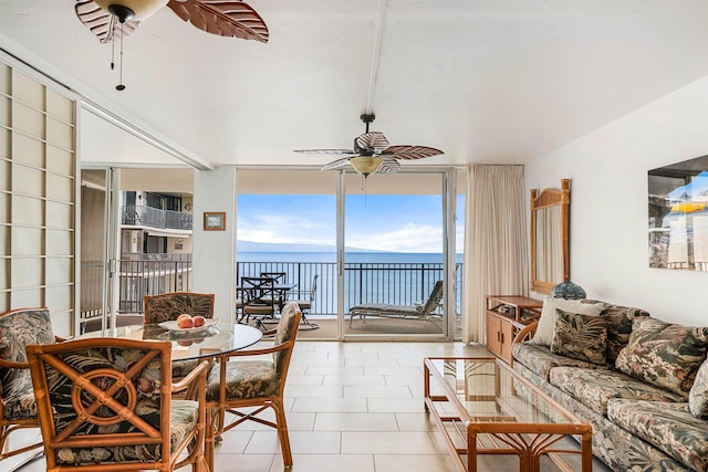 sunroom / solarium featuring a water view and ceiling fan