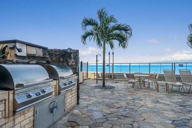 view of patio featuring a view of the beach, a water view, area for grilling, and a grill