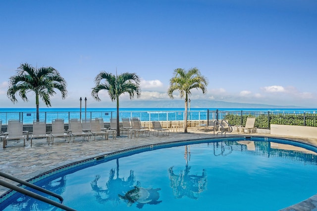 view of swimming pool with a water view and a patio area