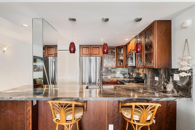 kitchen with kitchen peninsula, decorative backsplash, stainless steel appliances, and a breakfast bar area