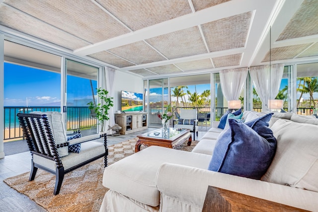 sunroom featuring a water view