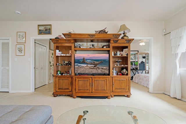 living area with baseboards and light carpet