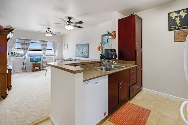 kitchen featuring white dishwasher, dark countertops, a sink, a peninsula, and open floor plan