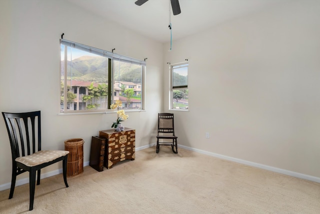 sitting room featuring carpet floors, baseboards, and ceiling fan