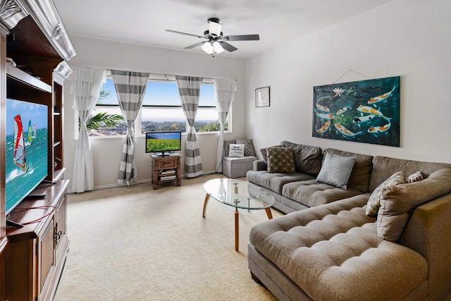living area featuring light colored carpet and a ceiling fan