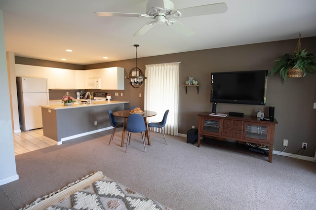 interior space featuring ceiling fan with notable chandelier, sink, and light carpet