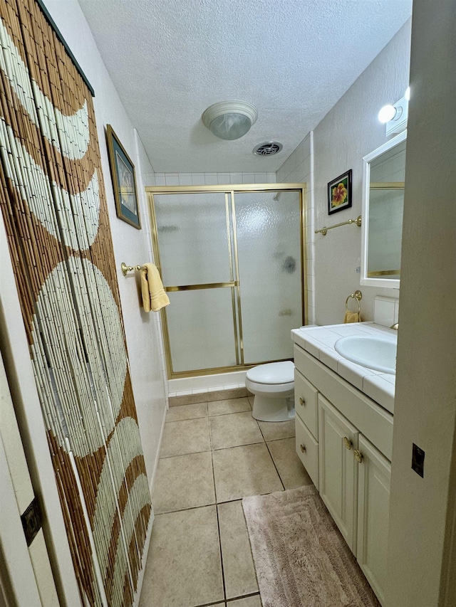 7146 Kamehameha V Hwy Unit C107, Kaunakakai, HI 96748 - full bathroom featuring a stall shower, a textured ceiling, tile patterned flooring, vanity, and toilet