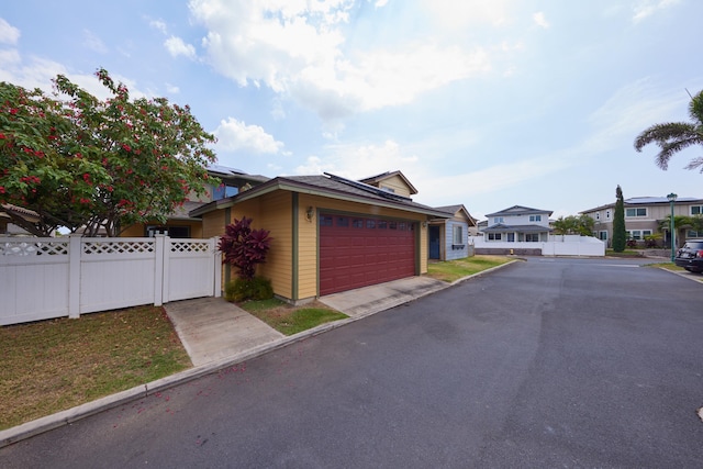 62 Meheu Cir, Kahului, HI 96732 - view of front of house with fence, driveway, a gate, and roof mounted solar panels