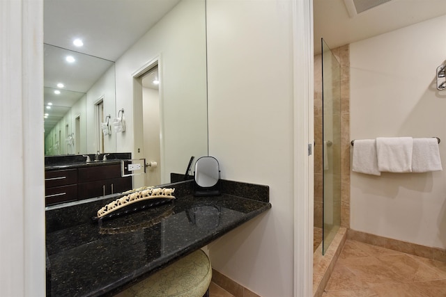 bathroom featuring recessed lighting, a sink, baseboards, a tile shower, and tile patterned floors