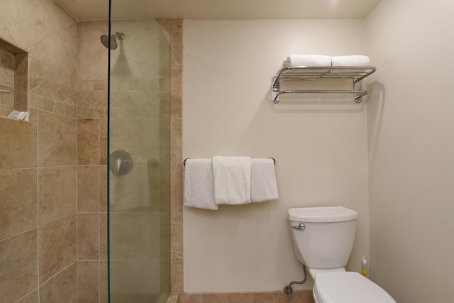 bathroom featuring toilet and a tile shower