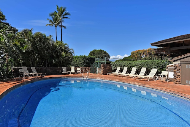 pool with a patio area and fence