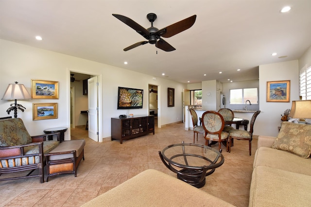 living room featuring baseboards, washer / dryer, a ceiling fan, and recessed lighting