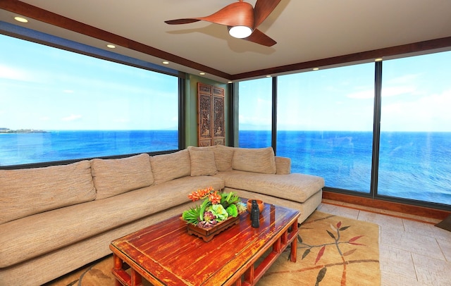 tiled living room with ceiling fan and a water view