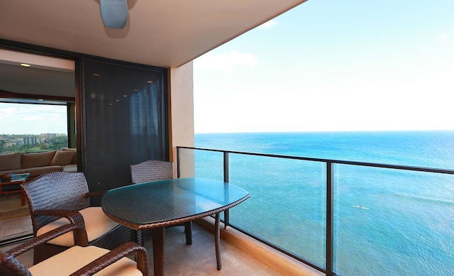 balcony featuring ceiling fan and a water view