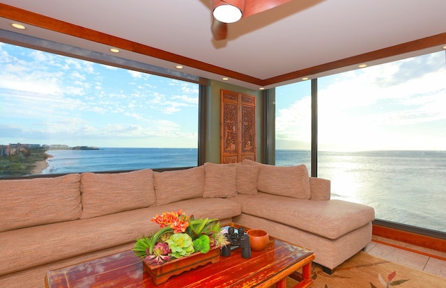 living room with plenty of natural light, light tile patterned flooring, and a water view