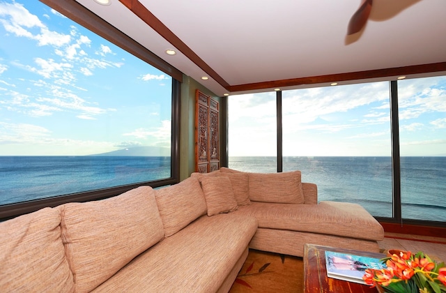 sunroom with ceiling fan and a water view