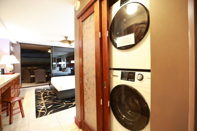 clothes washing area featuring stacked washer and clothes dryer and light tile patterned floors