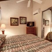 bedroom with ceiling fan and a wall mounted air conditioner