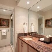 bathroom with tile patterned flooring, a shower with door, and vanity