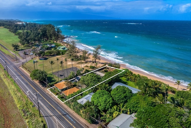 birds eye view of property with a water view and a beach view