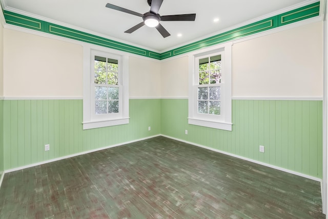 unfurnished room featuring a wealth of natural light, crown molding, ceiling fan, and dark wood-type flooring