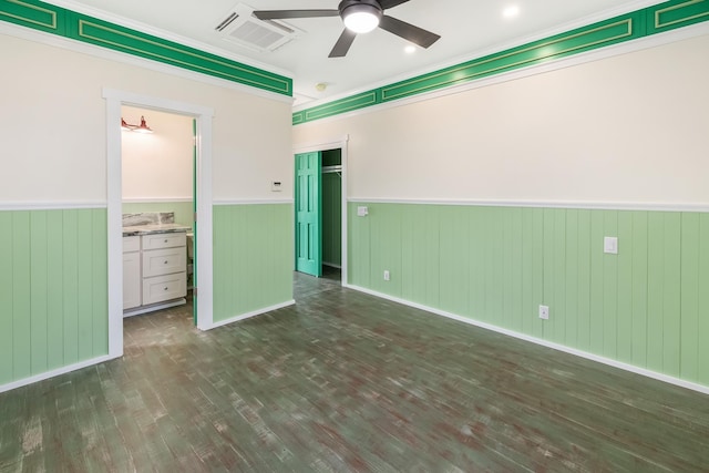 unfurnished bedroom with ensuite bathroom, dark hardwood / wood-style flooring, and ornamental molding