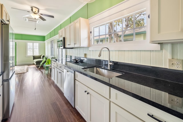 kitchen with stainless steel appliances, plenty of natural light, dark wood-type flooring, and sink