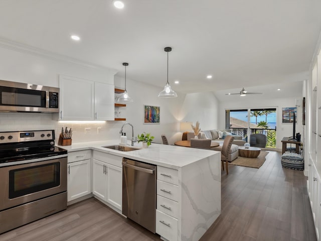 3950 Kalai Waa St Unit C202, Kihei, HI 96753 - kitchen featuring appliances with stainless steel finishes, a peninsula, backsplash, white cabinetry, and open floor plan