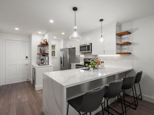 3950 Kalai Waa St Unit C202, Kihei, HI 96753 - kitchen featuring open shelves, appliances with stainless steel finishes, a peninsula, white cabinets, and dark wood-style flooring