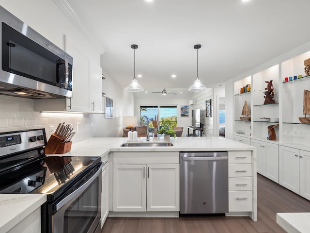 3950 Kalai Waa St Unit C202, Kihei, HI 96753 - kitchen with appliances with stainless steel finishes, a peninsula, dark wood-type flooring, ceiling fan, and white cabinetry