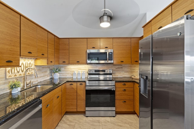 kitchen with brown cabinetry, a sink, stainless steel appliances, marble finish floor, and backsplash