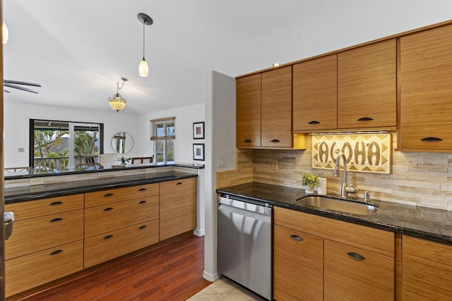 kitchen featuring tasteful backsplash, brown cabinets, dishwasher, and a sink