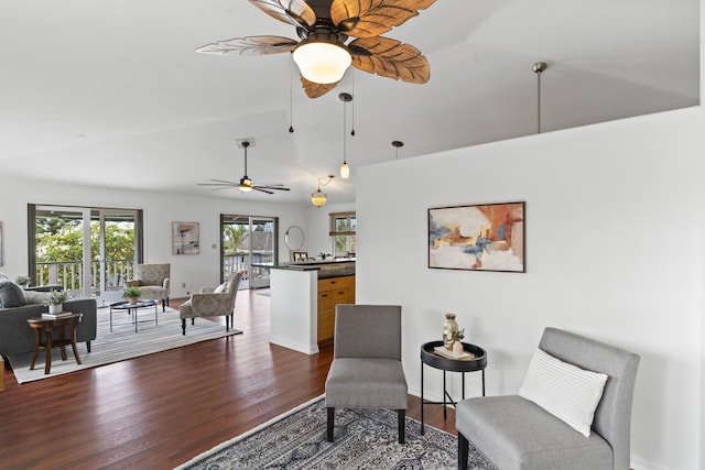 living area featuring lofted ceiling, dark wood-style floors, baseboards, and ceiling fan