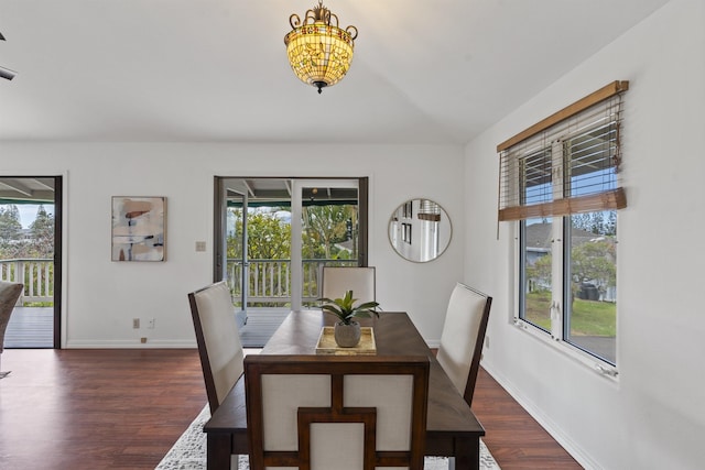 dining space featuring baseboards, plenty of natural light, and dark wood-type flooring